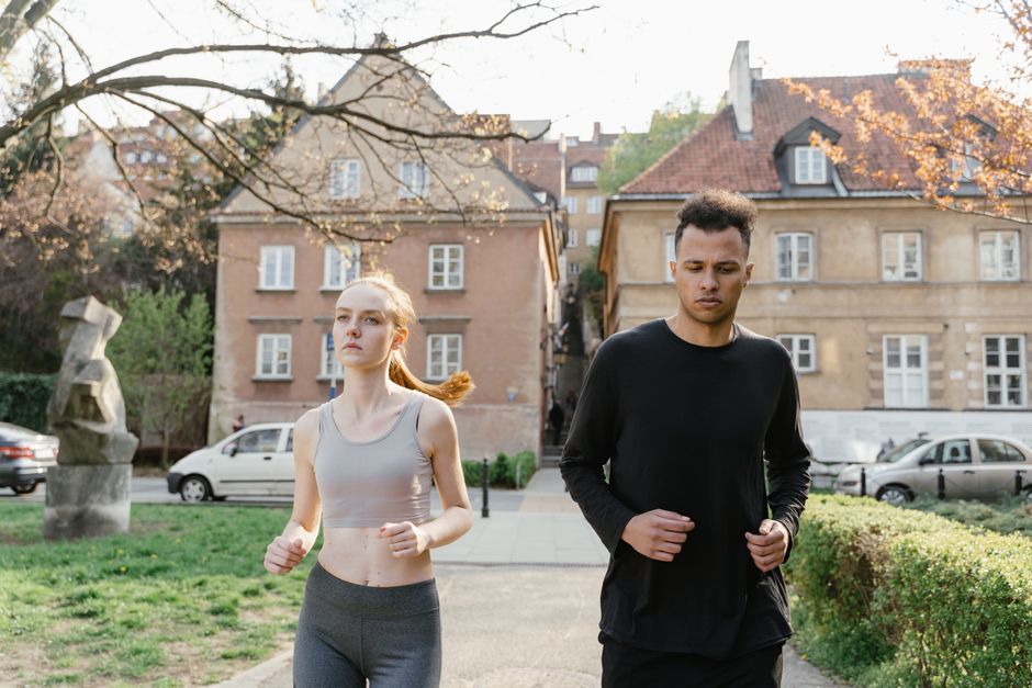 Mann läuft im Park beim joggen bei Frau vorbei