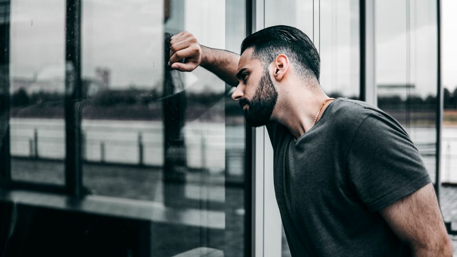 Mann gelangweilt am Fenster