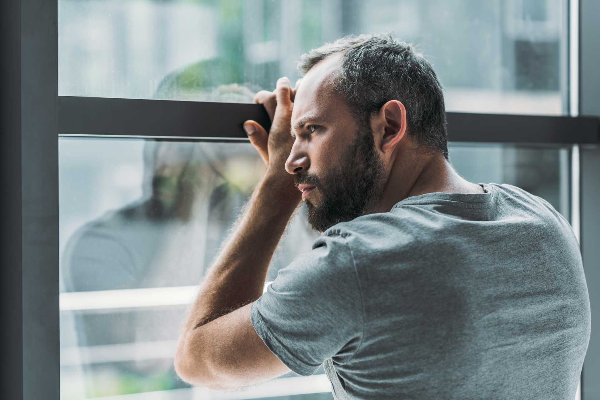 Mann gelangweilt am Fenster
